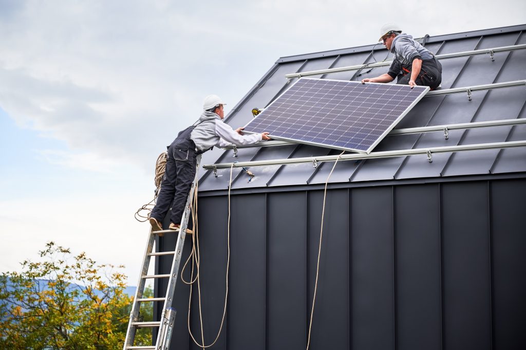 solar installers working on solar panel on roof